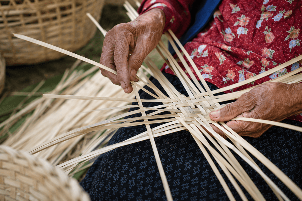 Artisan hand-weaving a natural fibre basket using traditional technique