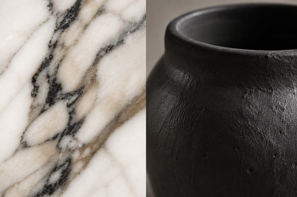 Close-up detail of natural marble veining beside matte black stone pottery texture